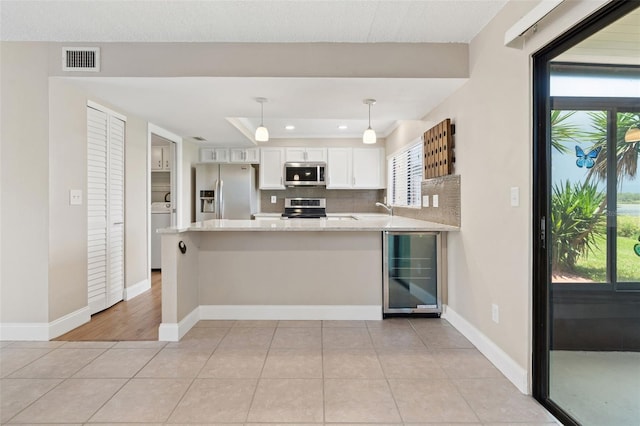 9209 Seminole Blvd Unit 13, Seminole, FL 33772 - kitchen with stainless steel appliances, beverage cooler, a peninsula, white cabinets, and recessed lighting