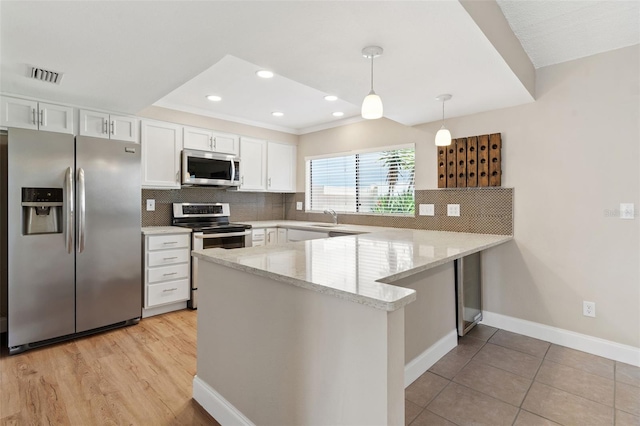 9209 Seminole Blvd Unit 13, Seminole, FL 33772 - kitchen with appliances with stainless steel finishes, a peninsula, white cabinets, backsplash, and recessed lighting