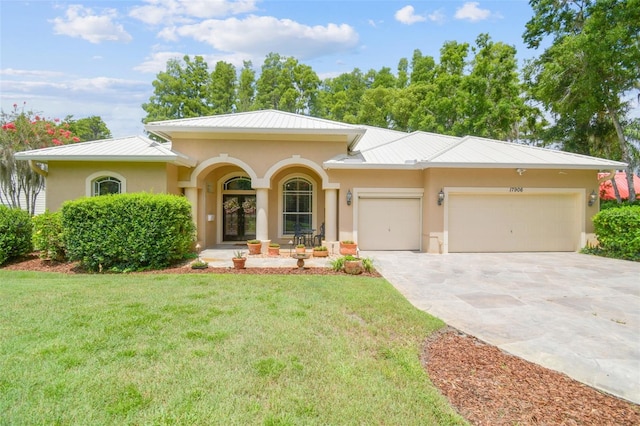 17906 Loretta Ln, Lutz, FL 33548 - mediterranean / spanish house with stucco siding, an attached garage, a front lawn, concrete driveway, and a metal roof
