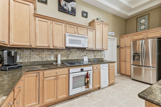 17906 Loretta Ln, Lutz, FL 33548 - kitchen featuring white appliances, backsplash, light brown cabinetry, light tile patterned flooring, and dark stone counters