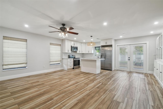 206 N Beverly Ave Unit 1/2, Tampa, FL 33609 - kitchen with stainless steel appliances, light countertops, light wood finished floors, french doors, and white cabinets
