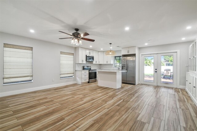 206 N Beverly Ave Unit 1/2, Tampa, FL 33609 - kitchen with stainless steel appliances, light countertops, light wood-style flooring, french doors, and open floor plan