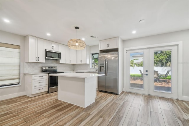 206 N Beverly Ave Unit 1/2, Tampa, FL 33609 - kitchen featuring appliances with stainless steel finishes, light wood finished floors, white cabinets, light countertops, and french doors