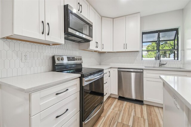 206 N Beverly Ave Unit 1/2, Tampa, FL 33609 - kitchen featuring appliances with stainless steel finishes, light countertops, white cabinetry, and backsplash