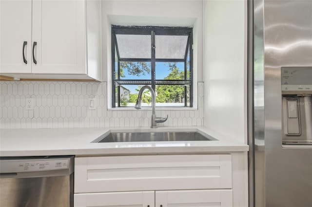 206 N Beverly Ave Unit 1/2, Tampa, FL 33609 - kitchen with stainless steel appliances, light countertops, white cabinetry, and backsplash