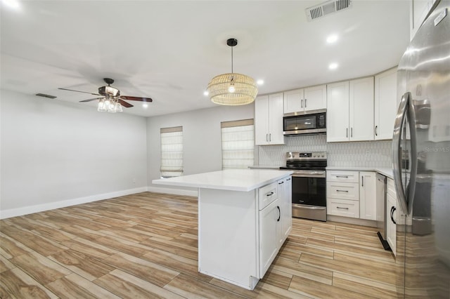 206 N Beverly Ave Unit 1/2, Tampa, FL 33609 - kitchen featuring stainless steel appliances, tasteful backsplash, light countertops, ceiling fan, and light wood-style flooring