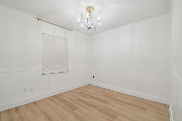 206 N Beverly Ave Unit 1/2, Tampa, FL 33609 - empty room with a chandelier, light wood-style floors, wainscoting, and a decorative wall