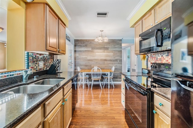 2025 Jefferson Ave, Dunedin, FL 34698 - kitchen featuring black appliances, ornamental molding, a chandelier, light wood-type flooring, and dark stone counters