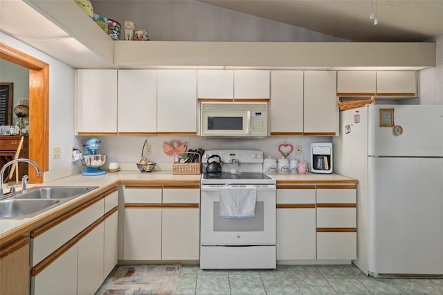 5301 Bayonne Ave, Spring Hill, FL 34608 - kitchen with white appliances, vaulted ceiling, light countertops, white cabinetry, and backsplash