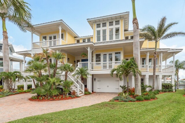 442 Midway Is, Clearwater Beach, FL 33767 - coastal inspired home featuring a balcony, decorative driveway, french doors, a front yard, and covered porch