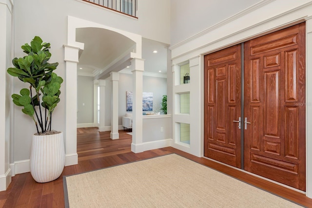 442 Midway Is, Clearwater Beach, FL 33767 - foyer with decorative columns, crown molding, wood finished floors, arched walkways, and recessed lighting