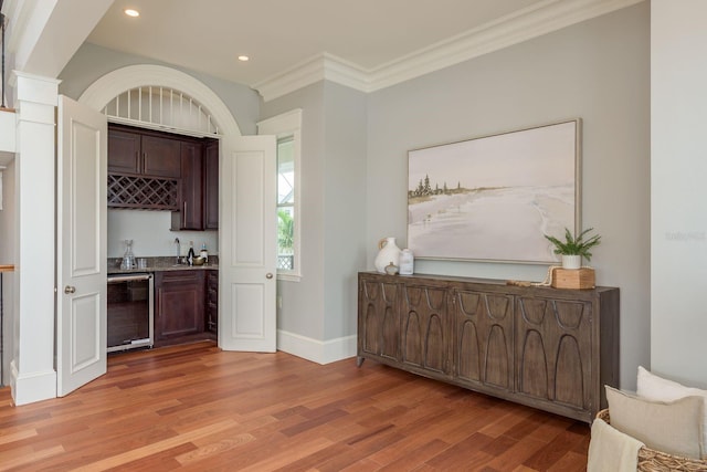442 Midway Is, Clearwater Beach, FL 33767 - indoor wet bar with beverage cooler, light wood finished floors, recessed lighting, ornamental molding, and decorative columns