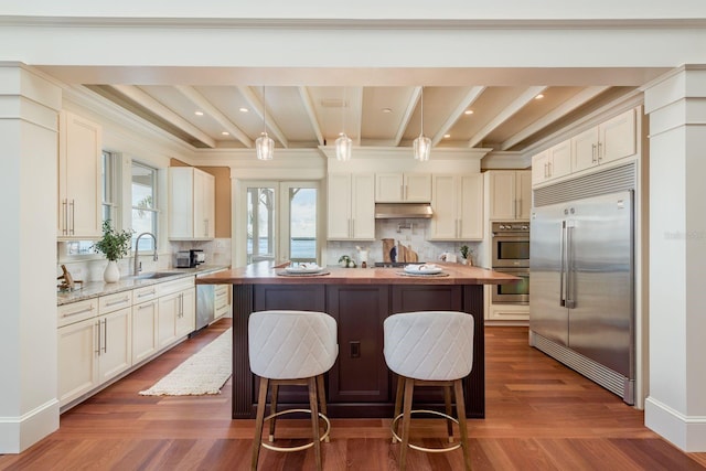 442 Midway Is, Clearwater Beach, FL 33767 - kitchen with butcher block counters, stainless steel appliances, a kitchen island, tasteful backsplash, and beam ceiling