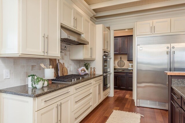 442 Midway Is, Clearwater Beach, FL 33767 - kitchen featuring appliances with stainless steel finishes, under cabinet range hood, dark wood finished floors, and tasteful backsplash