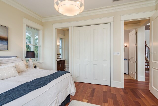 442 Midway Is, Clearwater Beach, FL 33767 - bedroom with dark wood-style flooring, a closet, and crown molding
