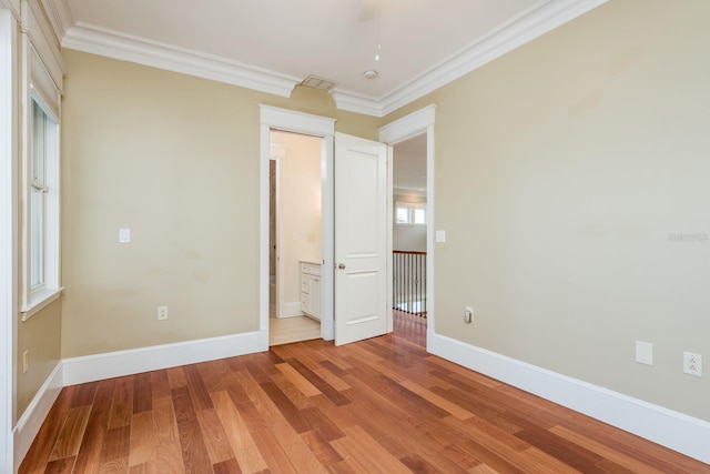 442 Midway Is, Clearwater Beach, FL 33767 - unfurnished bedroom with crown molding and light wood-style floors