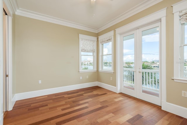 442 Midway Is, Clearwater Beach, FL 33767 - empty room with crown molding, light wood finished floors, and plenty of natural light