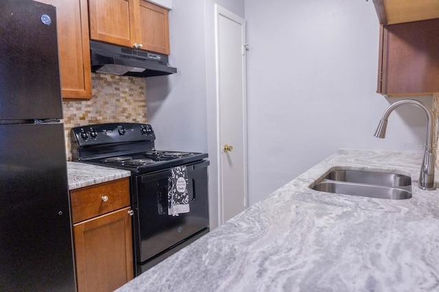 220 Berry Tree Pl Unit 220, Brandon, FL 33510 - kitchen with black appliances, under cabinet range hood, tasteful backsplash, and brown cabinetry