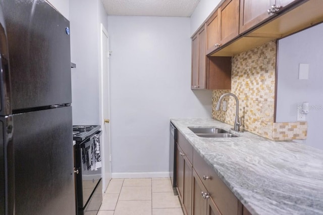 220 Berry Tree Pl Unit 220, Brandon, FL 33510 - kitchen with black appliances, decorative backsplash, light tile patterned floors, light stone counters, and brown cabinets