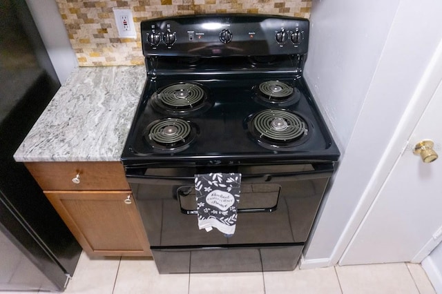 220 Berry Tree Pl Unit 220, Brandon, FL 33510 - kitchen view of black range with electric stovetop, brown cabinets, decorative backsplash, and refrigerator
