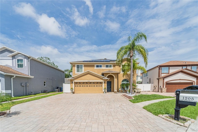 1205 Sweet Gum Dr, Brandon, FL 33511 - view of front of property with decorative driveway, solar panels, a garage, stucco siding, and a gate