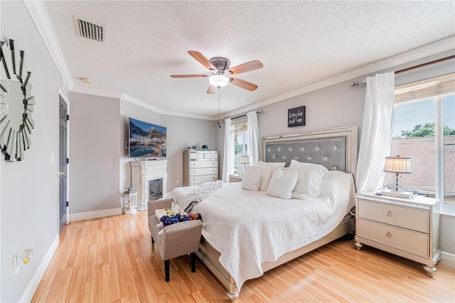 1205 Sweet Gum Dr, Brandon, FL 33511 - bedroom with light wood-type flooring, a textured ceiling, ornamental molding, a fireplace, and a ceiling fan