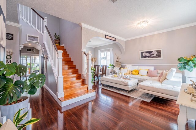 1205 Sweet Gum Dr, Brandon, FL 33511 - living room featuring arched walkways, stairs, wood finished floors, healthy amount of natural light, and a textured ceiling