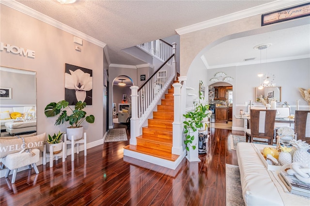 1205 Sweet Gum Dr, Brandon, FL 33511 - foyer with arched walkways, wood finished floors, stairs, crown molding, and a textured ceiling