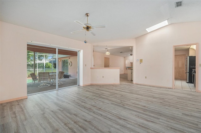 4355 Odin St, Spring Hill, FL 34608 - unfurnished living room with a ceiling fan, light wood-type flooring, vaulted ceiling, and a skylight