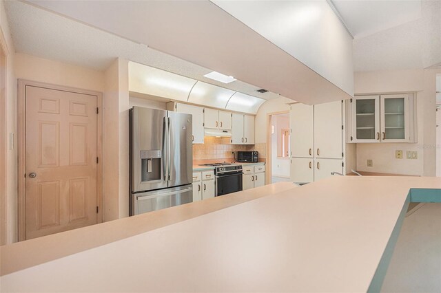 4355 Odin St, Spring Hill, FL 34608 - kitchen featuring stainless steel refrigerator with ice dispenser, gas range, black microwave, light countertops, and under cabinet range hood