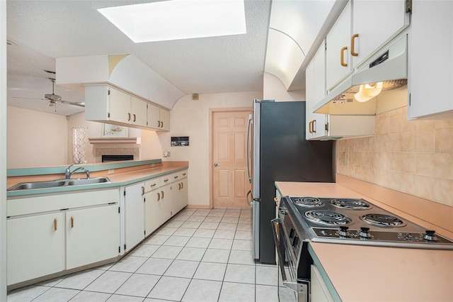 4355 Odin St, Spring Hill, FL 34608 - kitchen featuring range, a tiled fireplace, under cabinet range hood, a skylight, and a ceiling fan