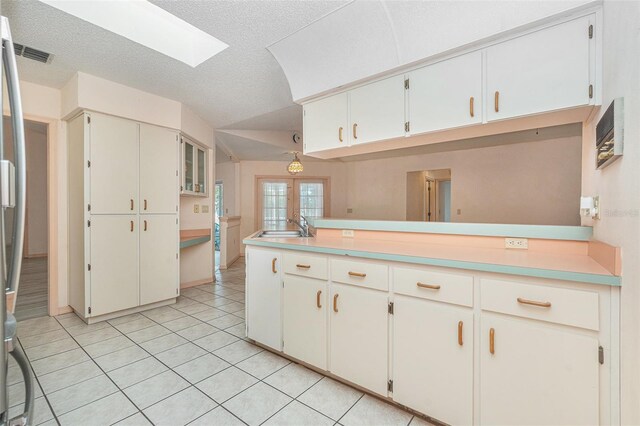 4355 Odin St, Spring Hill, FL 34608 - kitchen with light tile patterned floors, a skylight, light countertops, lofted ceiling, and a peninsula