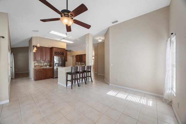 12405 Pathway Ct, Riverview, FL 33569 - kitchen with stainless steel fridge, light tile patterned flooring, tasteful backsplash, light countertops, and a breakfast bar area
