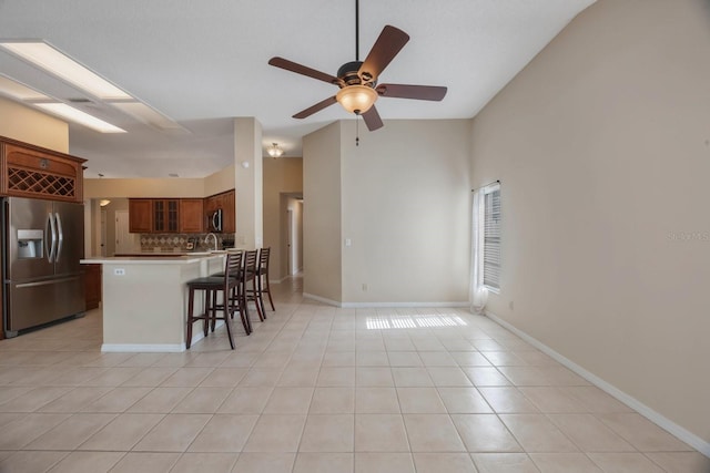12405 Pathway Ct, Riverview, FL 33569 - kitchen with stainless steel refrigerator with ice dispenser, glass insert cabinets, a ceiling fan, backsplash, and light tile patterned flooring