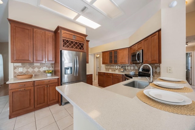 12405 Pathway Ct, Riverview, FL 33569 - kitchen with stainless steel appliances, light countertops, decorative backsplash, and brown cabinets