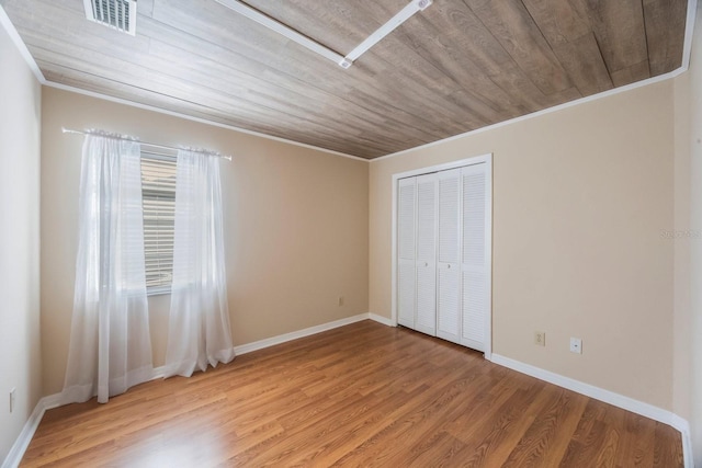 12405 Pathway Ct, Riverview, FL 33569 - unfurnished bedroom with ornamental molding, light wood-style floors, wood ceiling, and a closet
