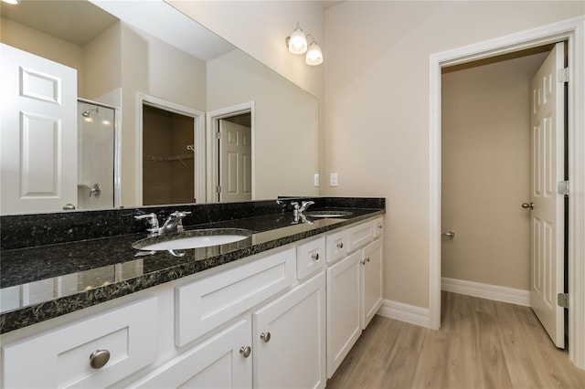 5909 Bibb Ct, North Port, FL 34288 - full bath featuring a stall shower, double vanity, wood finished floors, and a walk in closet