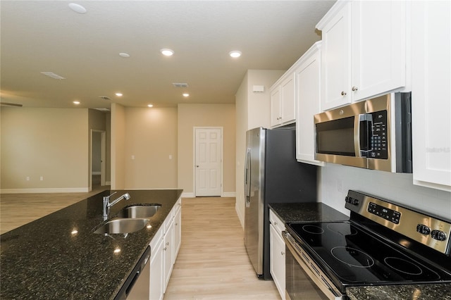 5909 Bibb Ct, North Port, FL 34288 - kitchen with appliances with stainless steel finishes, white cabinets, light wood finished floors, dark stone counters, and recessed lighting