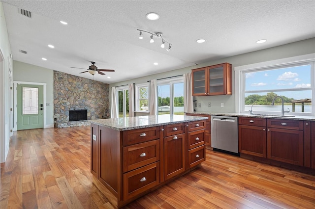 17 Freshwater Dr, Palm Harbor, FL 34684 - kitchen featuring dishwasher, a textured ceiling, ceiling fan, light wood-type flooring, and a stone fireplace