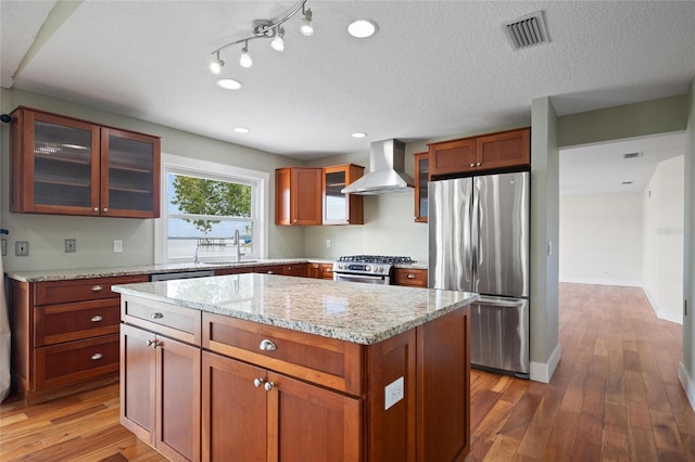 17 Freshwater Dr, Palm Harbor, FL 34684 - kitchen with stainless steel appliances, wall chimney range hood, wood-type flooring, a center island, and glass insert cabinets