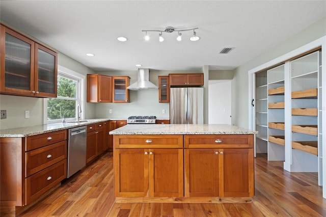 17 Freshwater Dr, Palm Harbor, FL 34684 - kitchen with stainless steel appliances, wall chimney exhaust hood, light wood-style floors, a center island, and recessed lighting