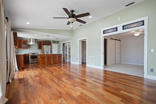 17 Freshwater Dr, Palm Harbor, FL 34684 - unfurnished living room featuring ceiling fan, a barn door, light wood-type flooring, and recessed lighting