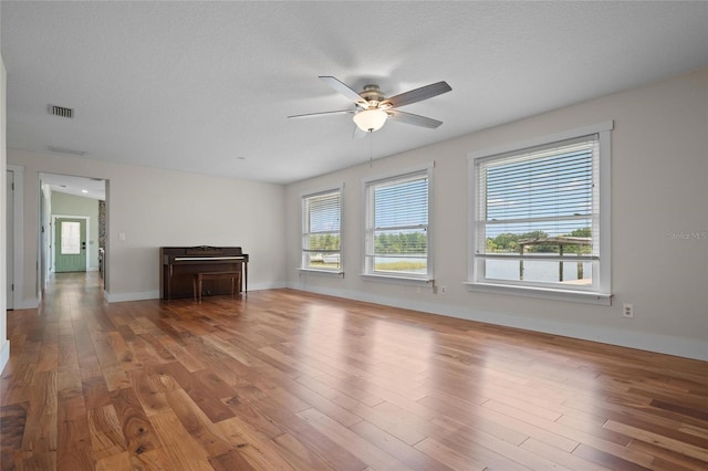 17 Freshwater Dr, Palm Harbor, FL 34684 - unfurnished living room with a ceiling fan, wood finished floors, and a textured ceiling