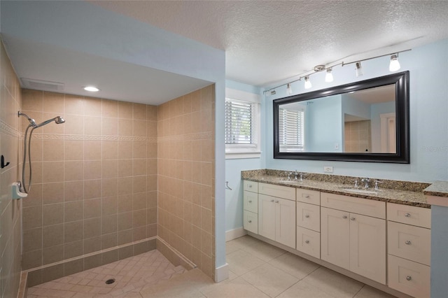 17 Freshwater Dr, Palm Harbor, FL 34684 - bathroom featuring a tile shower, double vanity, tile patterned floors, and a textured ceiling