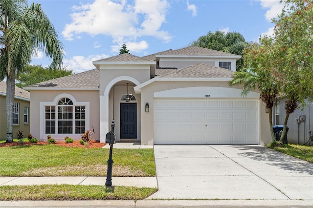 1800 Loch Haven Ct, Trinity, FL 34655 - mediterranean / spanish-style house with a garage, stucco siding, a front lawn, driveway, and roof with shingles