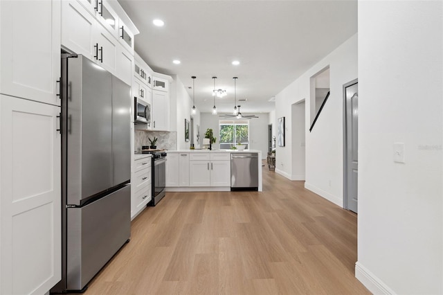 1800 Loch Haven Ct, Trinity, FL 34655 - kitchen featuring appliances with stainless steel finishes, a peninsula, light wood-style flooring, light countertops, and white cabinetry