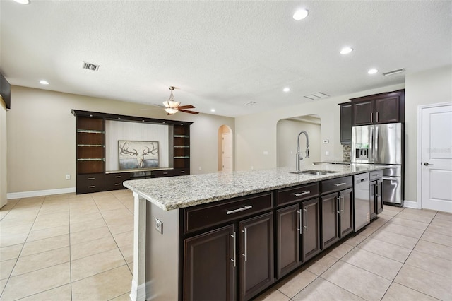 4544 Vermillion Sky Dr, Wesley Chapel, FL 33544 - kitchen with appliances with stainless steel finishes, arched walkways, light tile patterned floors, an island with sink, and ceiling fan