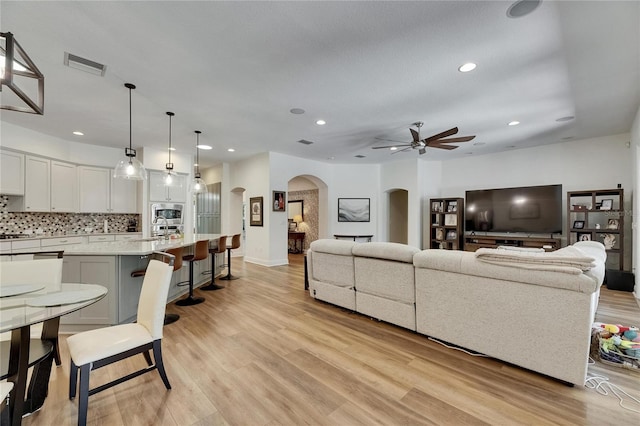 5804 Terncrest Dr, Lithia, FL 33547 - living room with arched walkways, a ceiling fan, light wood finished floors, and recessed lighting