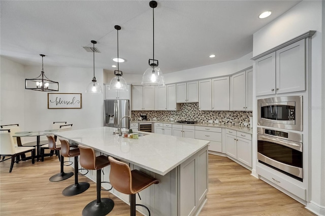 5804 Terncrest Dr, Lithia, FL 33547 - kitchen featuring stainless steel appliances, decorative backsplash, light wood-style flooring, light countertops, and recessed lighting