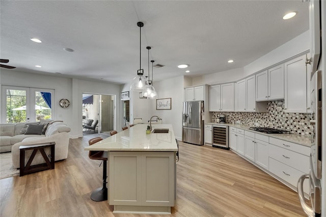 5804 Terncrest Dr, Lithia, FL 33547 - kitchen with stainless steel fridge, beverage cooler, open floor plan, gas cooktop, and a kitchen bar